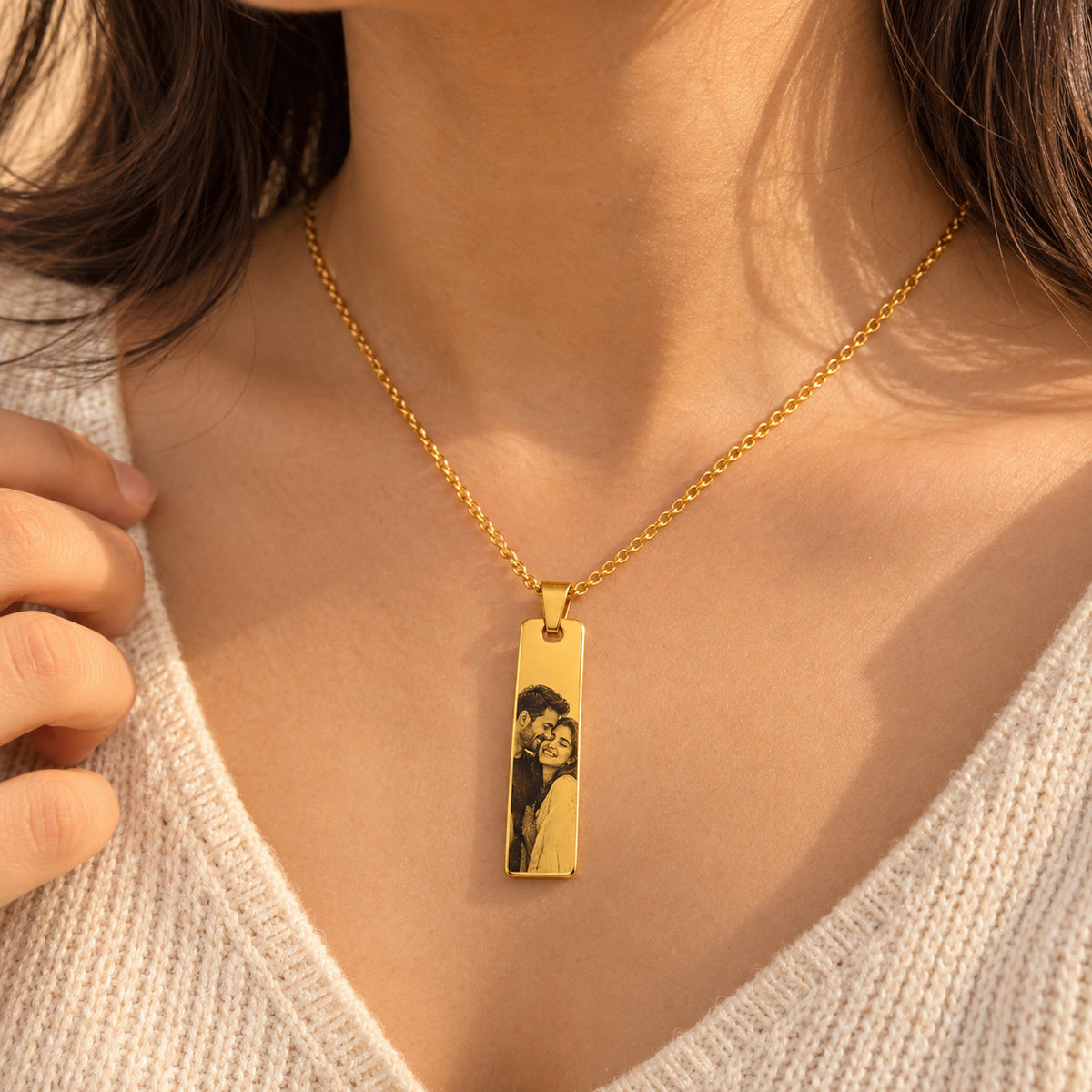 Gold couple photo bar pendant worn by a woman