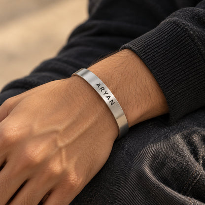 Silver name cuff bracelet worn on a man's wrist