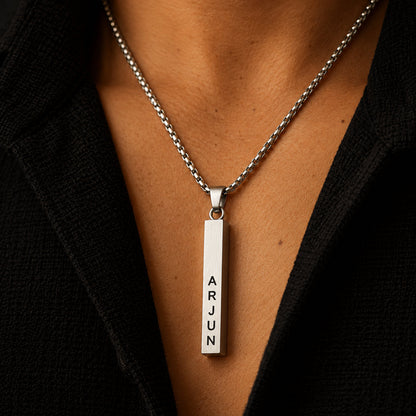Silver vertical name bar pendant worn with a black shirt