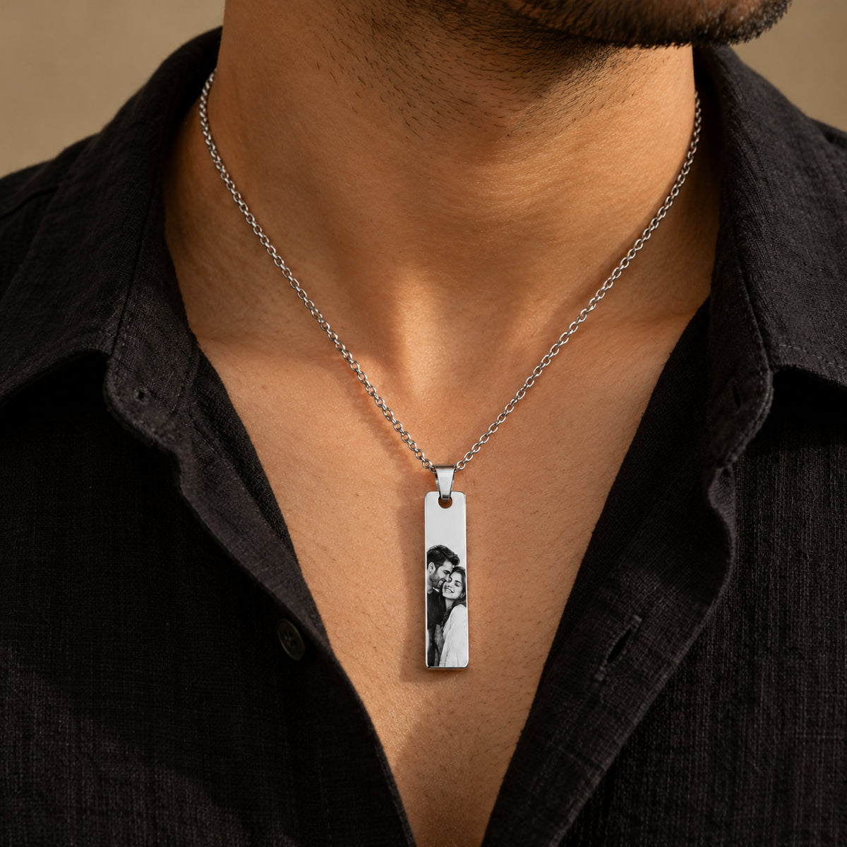 Silver couple photo bar pendant worn by a man