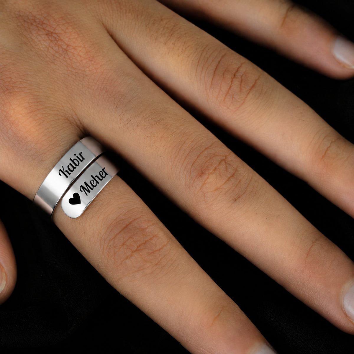 Silver couple name wrap ring worn on a finger