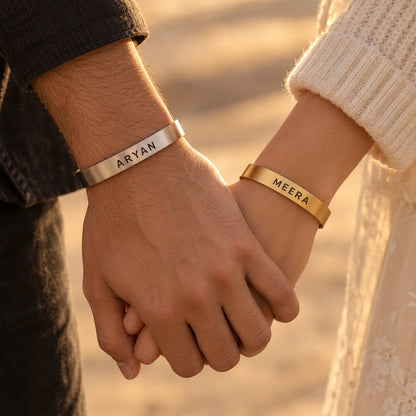 Couple wearing matching silver and gold name cuff bracelets